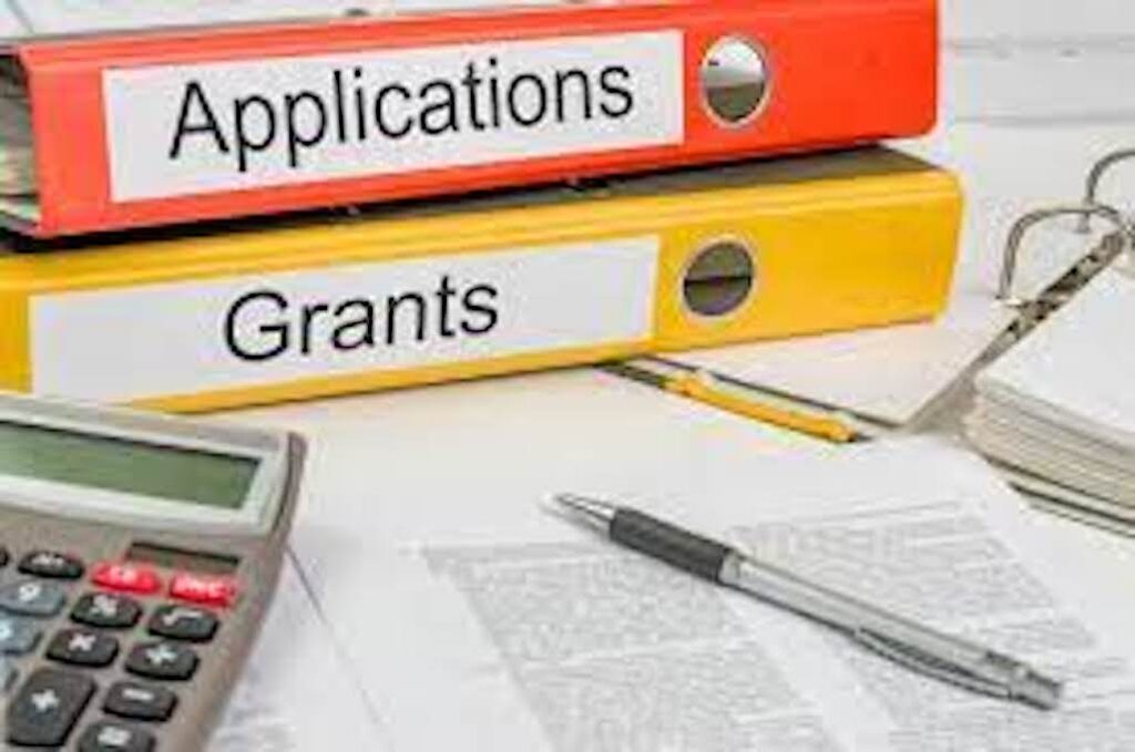 An image of a stack of two binders. The top says Applications and the bottom one says Grants.