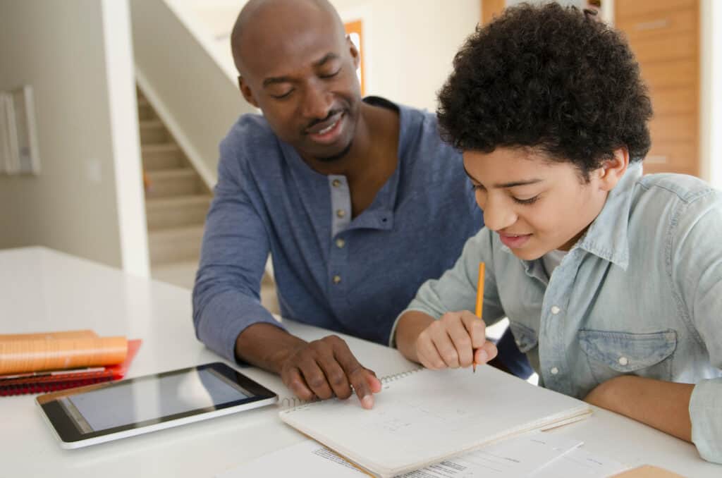 Father helping teenage son with homework