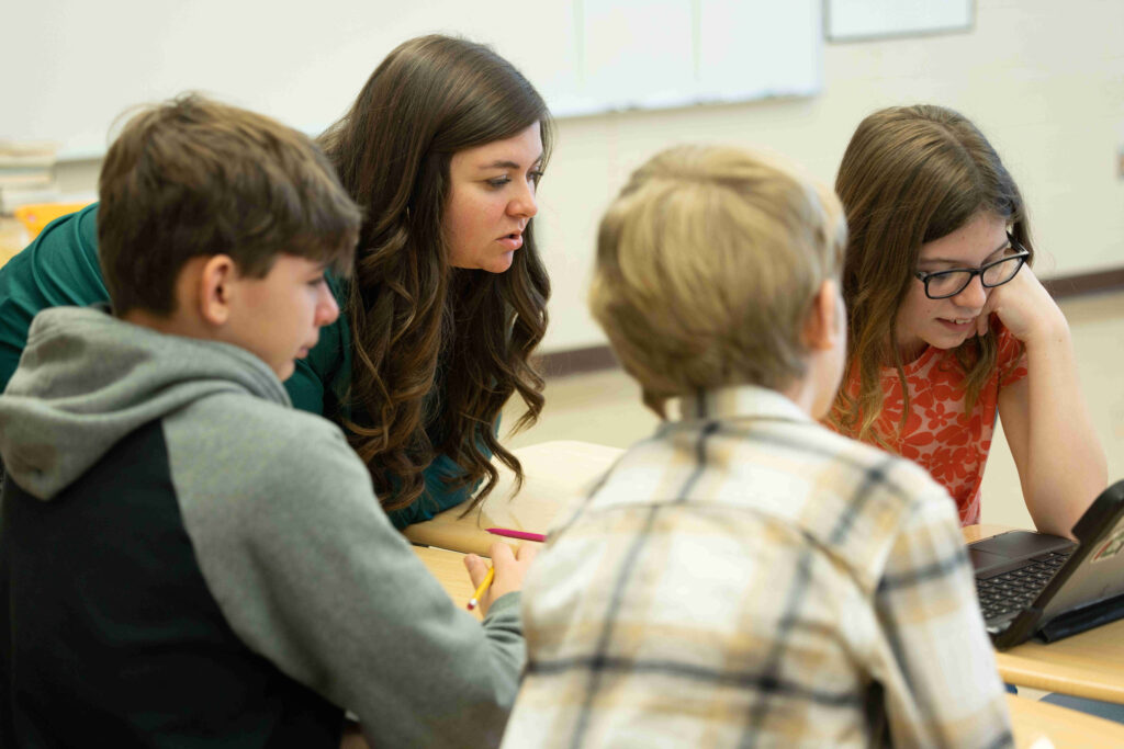 Teacher collaborating with 3 students